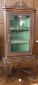 A Victorian carved oak corner cupboard with swan neck pediment, guilloche carving, the glazed
