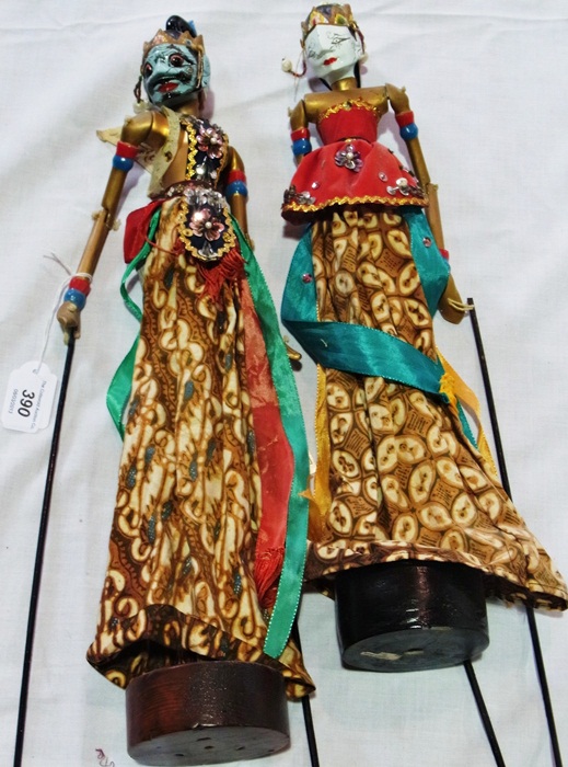 Two painted wood hand-held jointed puppets, wearing ornate painted masks and jewelled clothing