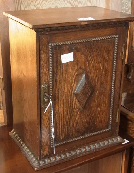 Early twentieth century oak smoker's cabinet, with split bobbin decorations, the door enclosing a