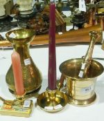 A brass pestle and mortar, brass chamberstick, Indian brass vase, circular dish and further