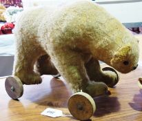 Early worn plush English bear on wheels, with button eyes