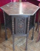 Twentieth century stained oak hexagonal two-tier table, with carved panels