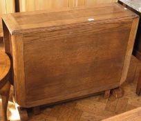 Twentieth century oak drop flap dining table with carved reeded pedestal supports, width 90cms