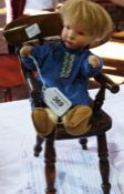 A doll's wooden kitchen chair together with a composition-headed boy doll with wire legs and