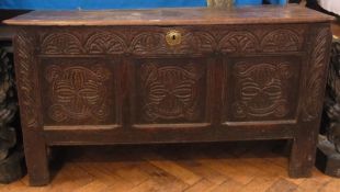 An 18th century oak three panel coffer, with lunette carved frieze over three carved panels