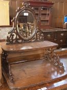 Late Victorian oak mirror back with two open racks, with carved scroll supports, width 51cms