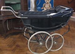 A navy blue coach pram with hood and covers etc