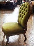 Late Victorian walnut framed nursing chair, upholstered in green buttonback velvet, on carved