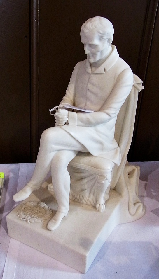 A Victorian Parian figure of the Duke of Wellington seated in a reflective mood, raised on a