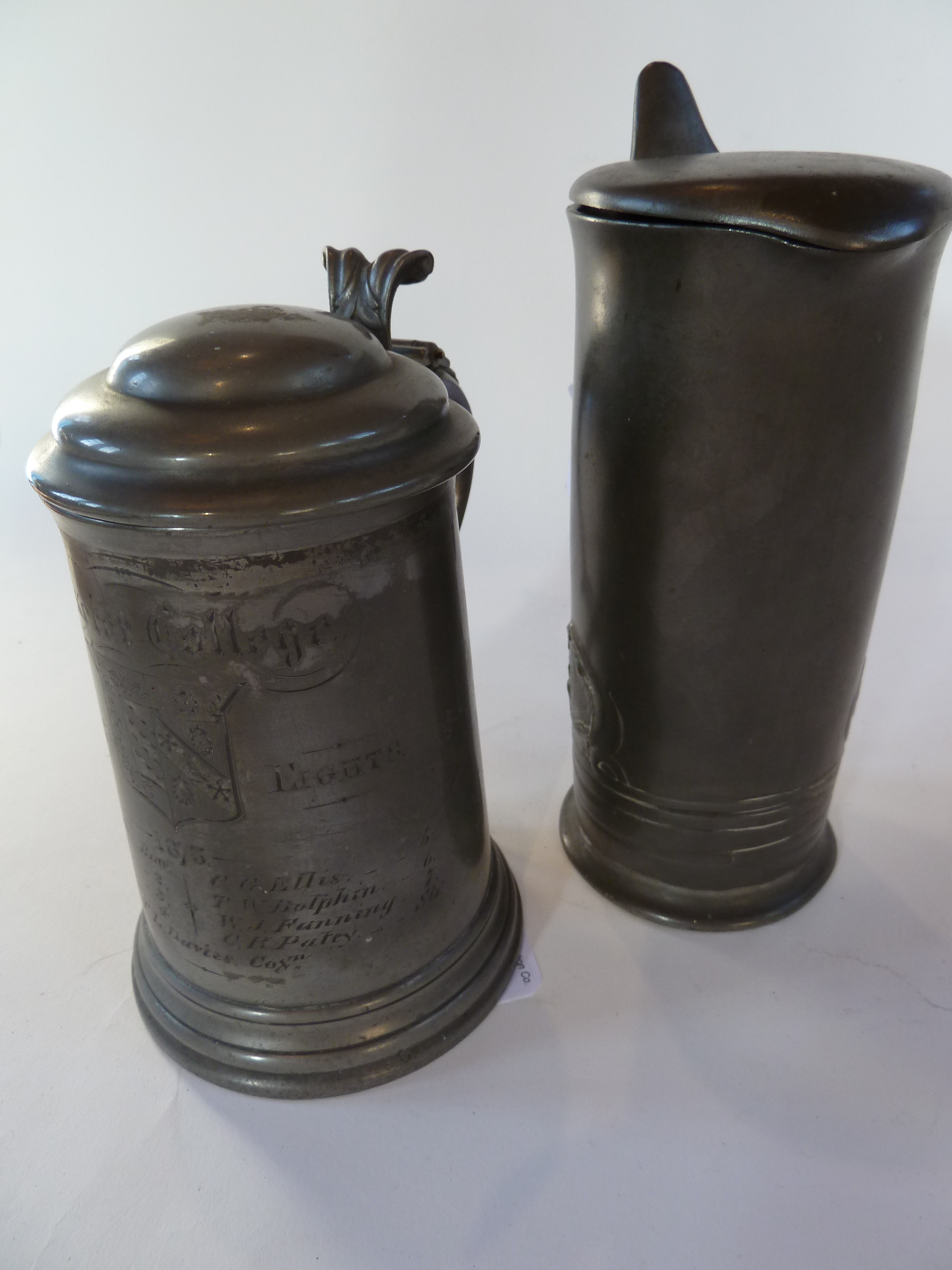 Two pewter tankards, one marked "Exeter College Scratch Eights - 1875" with glass bottom and