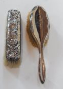 A George V silver-backed hairbrush, Chester 1911 together with a silver-backed clothes brush, cherub
