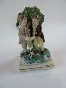 A Pearlware flatback figure group of two men together with dog