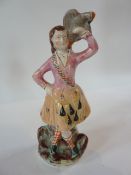 A 19th century Staffordshire figure  of a lady holding a bird