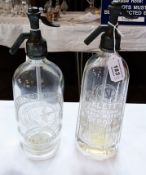 Two glass soda siphons, one marked "Cheltenham Spa Mineral Water Company" and the other "Niblett's