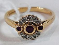 14ct gold red stone and diamond cluster ring, set three circular red stones, possibly rubies, within