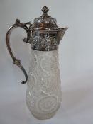 A cut glass claret jug with silverplated mounts to lid and handle, depicting Middle eastern designs,