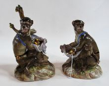 Pair of Meissen monkey figures of mother and child seated by a tree trunk holding fruit and
