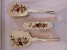 Silver enamel dressing table set, (three pieces), green ground decorated with roses, Birmingham