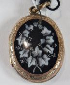 Victorian gold-coloured metal and enamel locket pendant, oval and decorated with ivy leaves on a