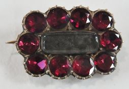 Late Georgian garnet set gold-coloured metal mourning brooch, rounded oblong, set ten facet cut