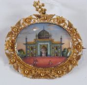 Indian gold pictorial miniature brooch, oval, depicting Indian palace in landscape and having