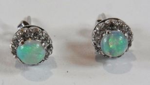 Pair opal and diamond earrings, the circular open surrounded by diamond border all set in white