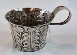 An Edwardian silver Arts and Crafts cup, with flared rim, repousse stemmed flower decoration, and