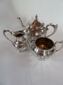 A silverplate part tea service viz:- teapot, cream jug and sugar bowl with engraved chased design (