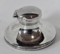George V silver capstan-shaped inkwell with hinged cover, raised on a circular spreading base,