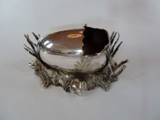 A late Victorian plated spoon warmer in the form of an open  oval shell on a rock style base, with