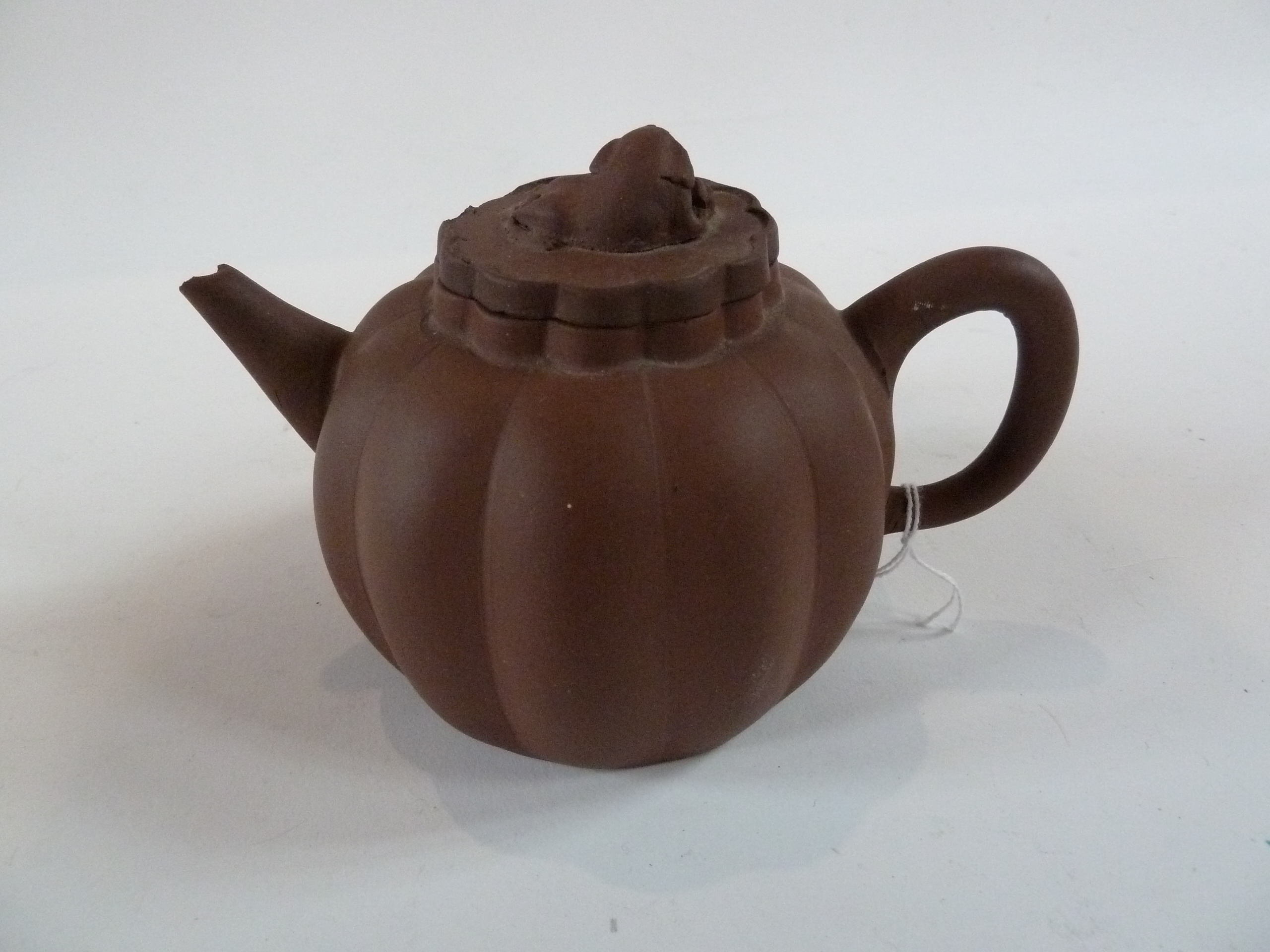 Oriental terracotta teapot, melon shaped and lobed, the lid with kylin finial