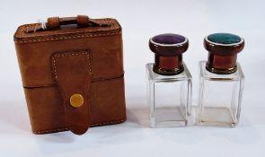 Pair of scent bottles, with green and amethyst coloured enamel tops, square cut glass bottles, in