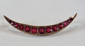 9ct gold crescent brooch, set ruby-coloured graduated stones alternating with tiny diamonds