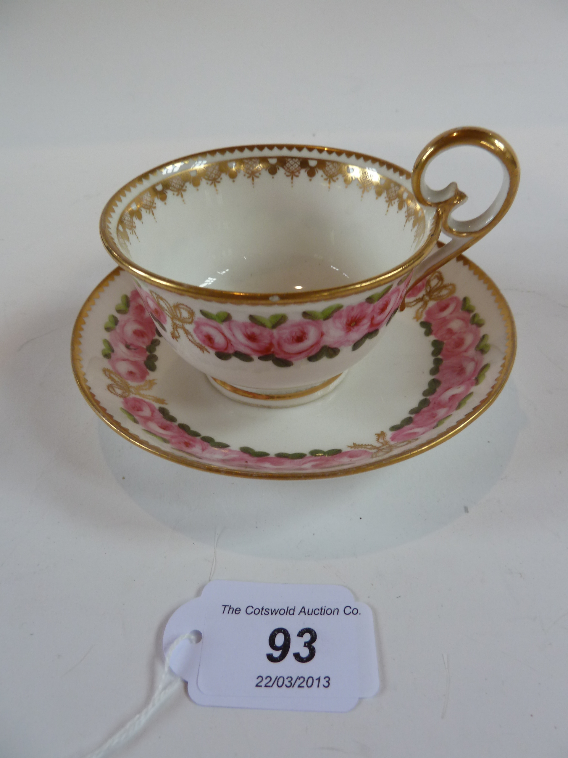 A Nantgarw porcelain cabinet cup and saucer, decorated with pink roses and gilt border