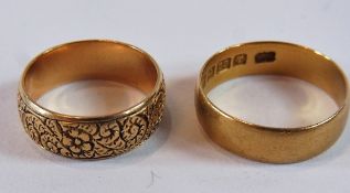 18ct gold wedding ring, floral and scroll engraved and another 22ct gold wedding ring