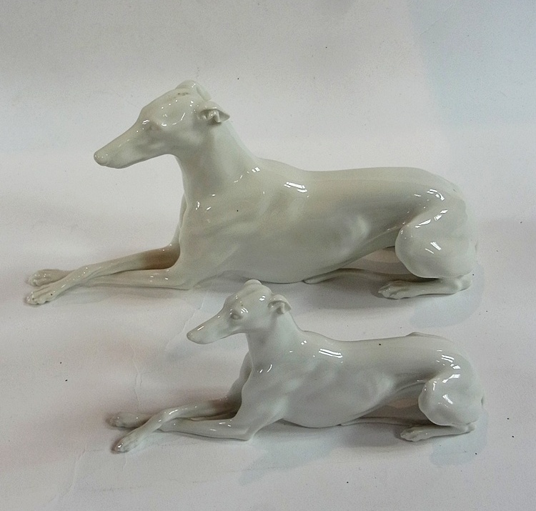 A Vienna porcelain figure of a greyhound seated with crossed legs, length 26cm together with another