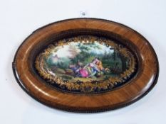 French oval porcelain painted plaque, pastoral scene with young lovers, a dog and sheep, floral gilt