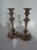 A pair of silverplate candlesticks, repousse decorated