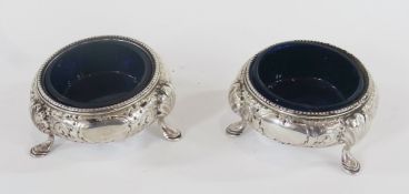 Pair Victorian silver circular open salts, with floral scrollwork decoration, raised on short