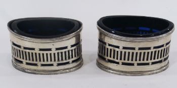 Pair of George V oval silver mustard pots, with reeded borders, pierced fretwork design, with blue