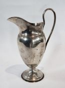 An Edwardian silver jug, of plain classical ewer form, raised on a circular foot, London 1904,