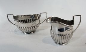 An Edwardian silver cream jug and matching sugar basin, of reeded form, Birmingham 1903, 5ozs
