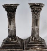 Pair George V silver Corinthian column candlesticks, raised on square stepped base, Sheffield