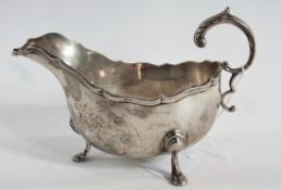 George V silver sauce boat, with wavy edge, foliate scroll handle, raised on cabriole legs with
