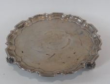 George V silver salver, with piecrust border, and foliate scrollwork legs, London 1912, diameter