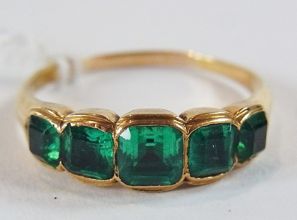 Gold and emerald coloured ring, set five square, graduated stones