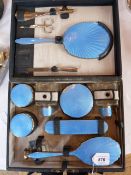 A fitted dressing table travelling set, dark blue enamel with silver-coloured metal mounts,