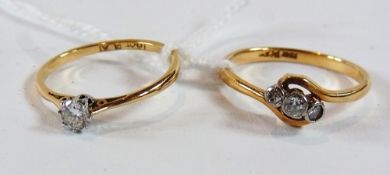 18ct gold and platinum solitaire diamond and another 18ct gold three-stone diamond ring, in twist