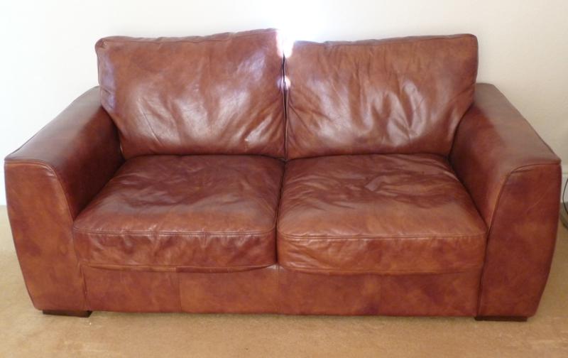 Tan-coloured hide upholstered three-seater settee, with loose squab cushions, 176cm wide