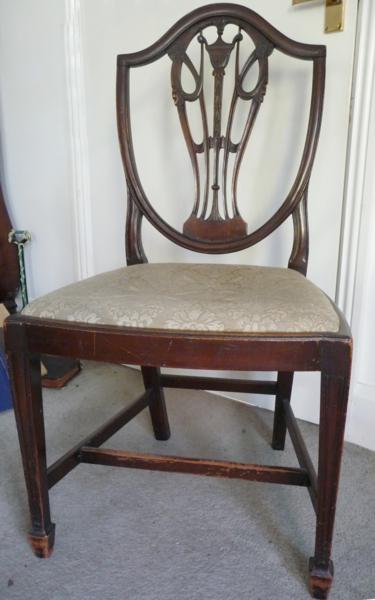 A set of eight mahogany shield-back dining chairs with carved and pierced splats, tapering